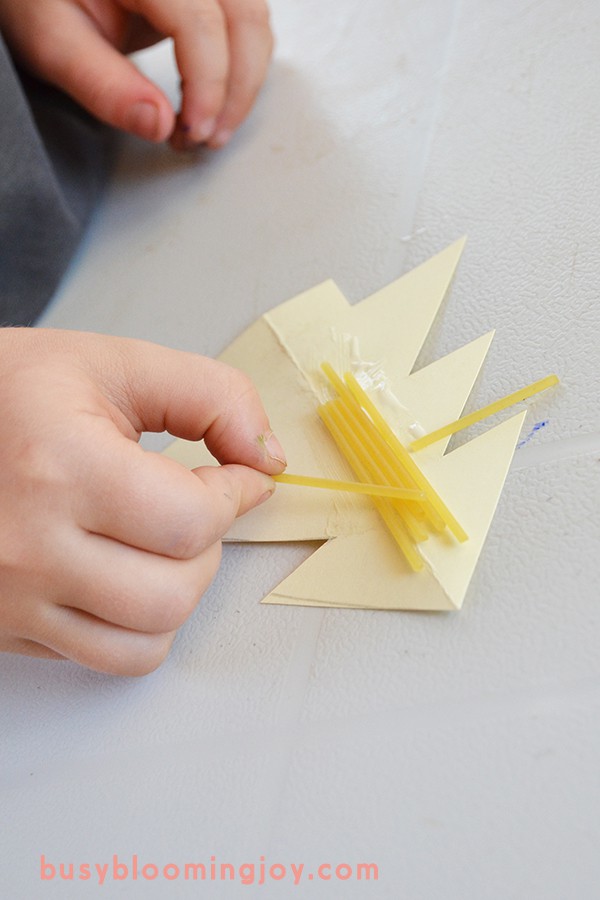 sticking pasta for Christmas tree ornament