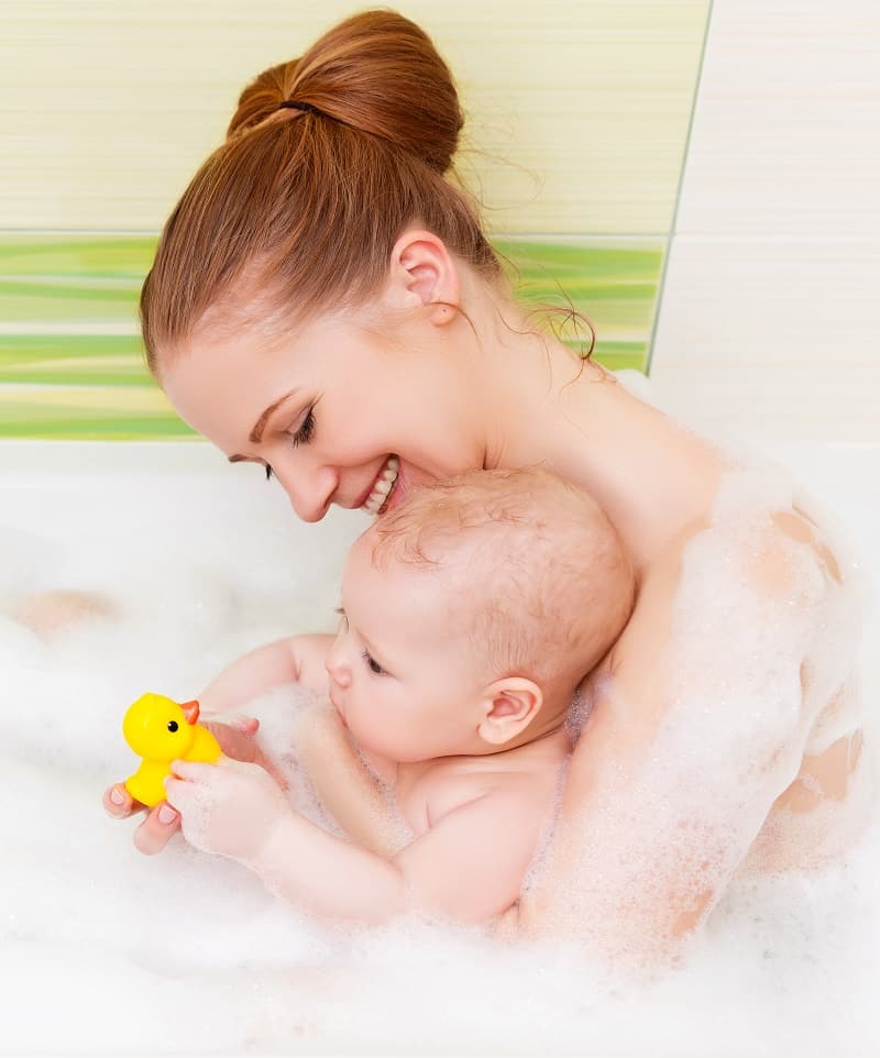 You might need to jump in the bath with baby when learning how to bathe your newborn