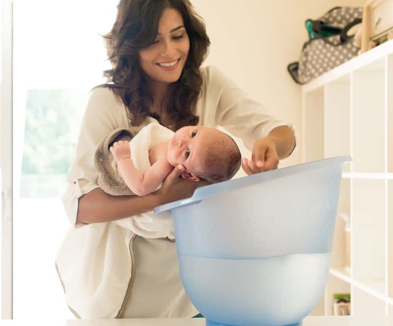 To wash a newborns hair, lie them along your forearm and sprinkle water over the head into a bucket or bath