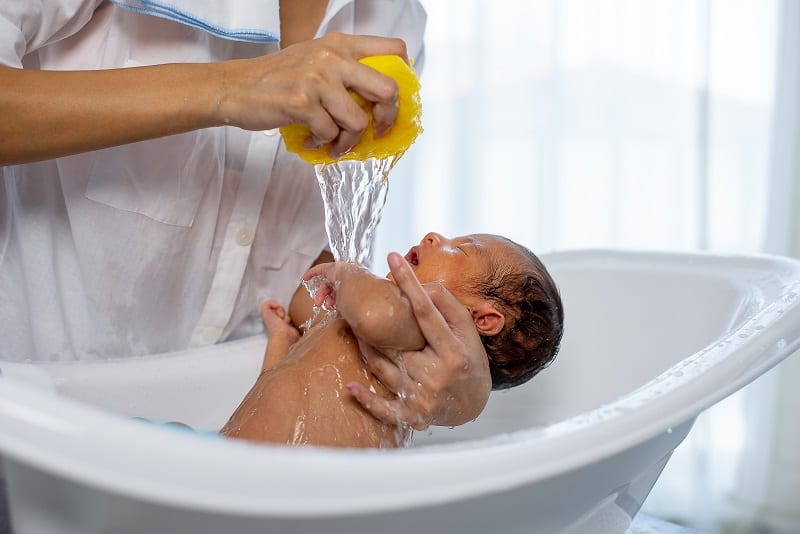 When bathing your newborn, they may enjoy having water squeezed over them