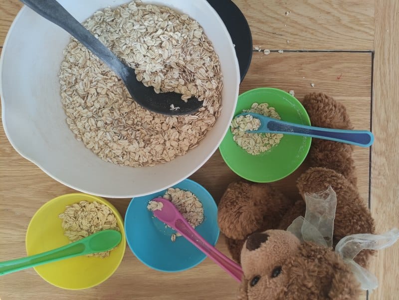 Dishing up the porridge for teddy - a fun messy tray idea