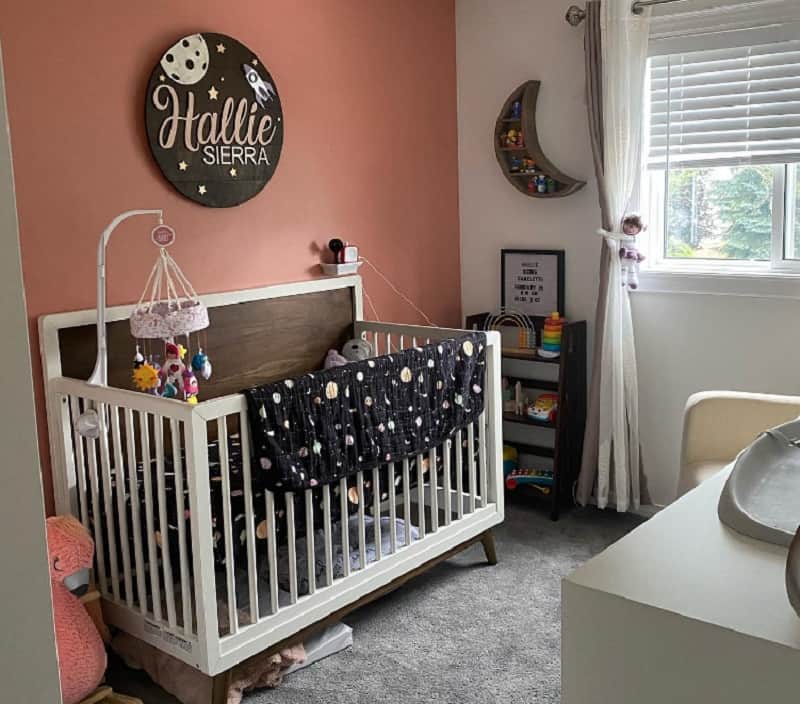 space themed nursery girl with dusty mauve wall