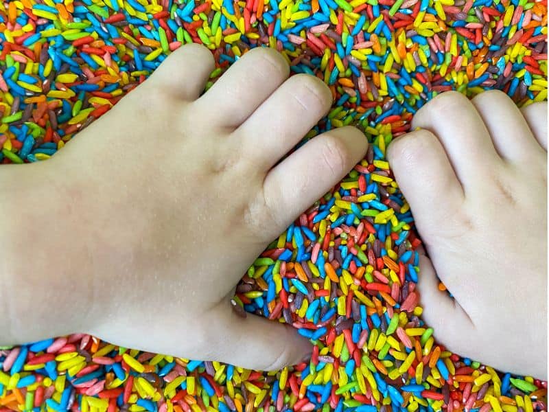 Uncooked colored rice is a fun sensory play for toddlers