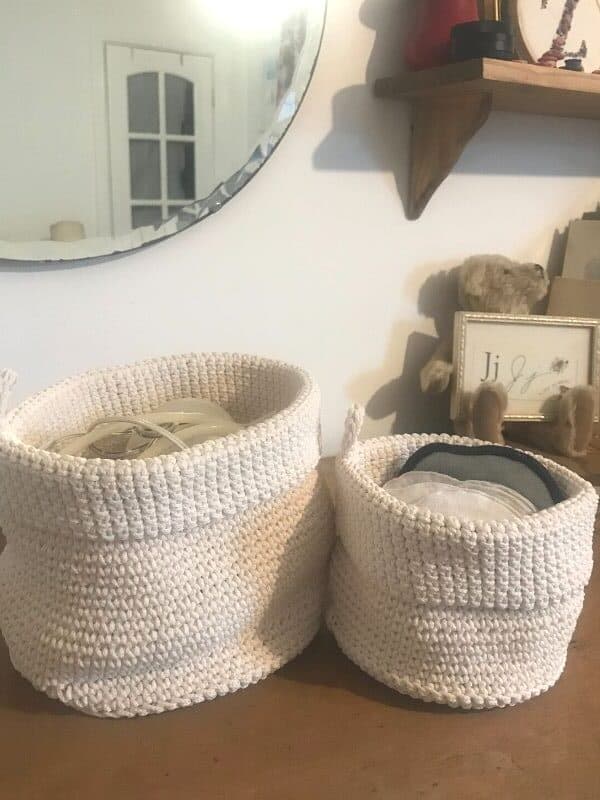 white storage baskets make organizing the nursery dresser and drawers simple