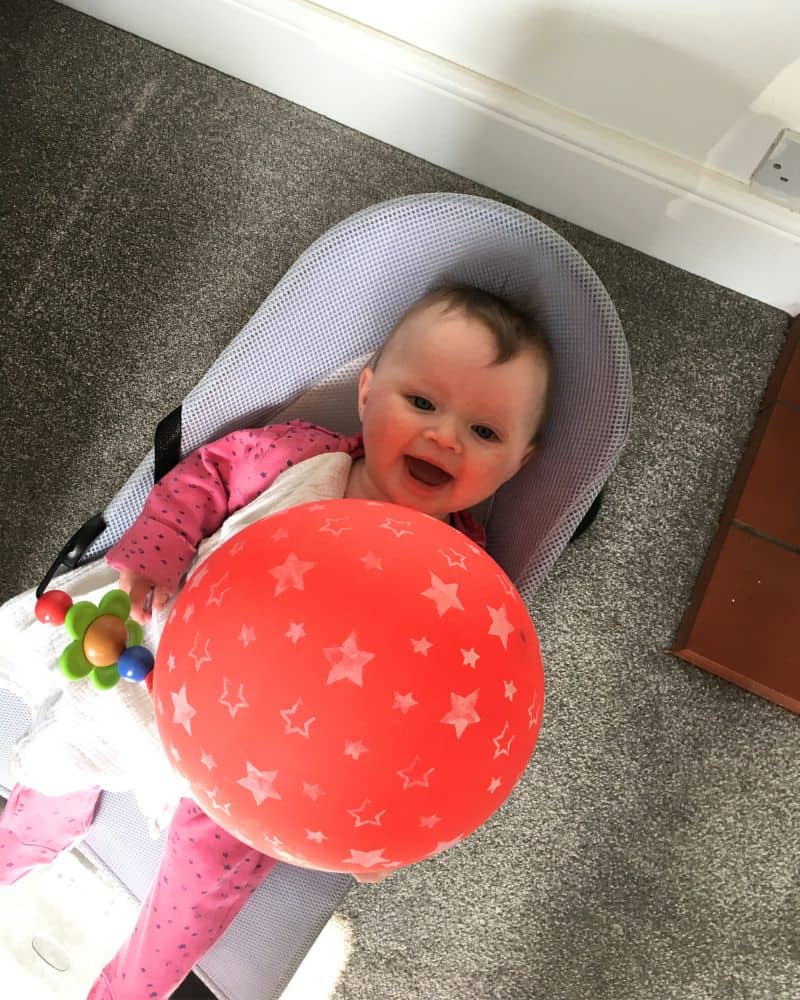 playing with a balloon is a fun indoor activity for three month old 