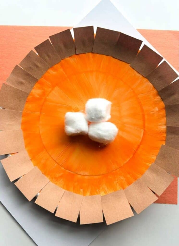 pumpkin pie craft with painted orange paper plate, brown paper crust and cotton ball as whipped cream